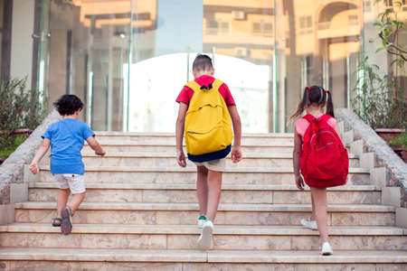 Back to school. Pupils with backpacks going to school togetherの写真素材