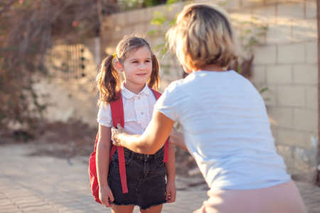 Mother meeting pupil from the school. Back to school. Parent and children relationships.の写真素材