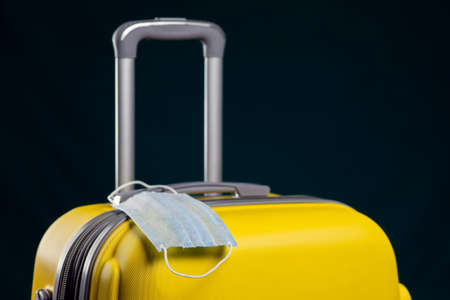 Medical mask on luggage. Travel during coronavirus time. Studio shotの写真素材