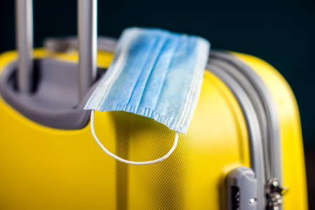 Medical mask on luggage. Travel during coronavirus time. Studio shotの写真素材