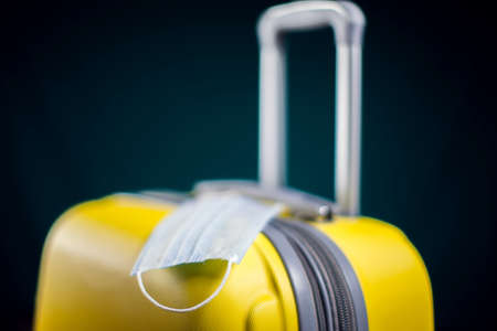 Medical mask on luggage. Travel during coronavirus time. Studio shotの写真素材