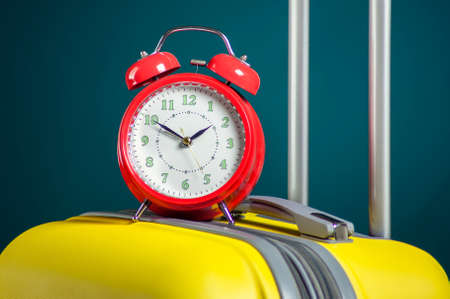 Alarm clock on luggage. Travel and holiday concept. Studio shotの写真素材