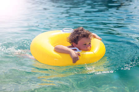 Kid on beach with swimming circle. Boy swimming in sea. Children and holiday conceptの写真素材