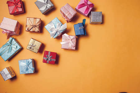 Gift boxes of different colors on yellow background. Celebration, party and shopping conceptの写真素材