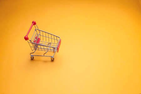 Empty trolley on yellow background. Shopping conceptの写真素材