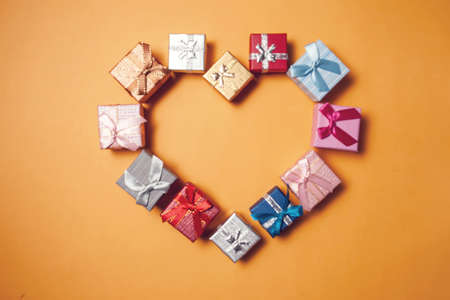 Gift boxes lying in the shape of heart on yellow background. Celebration and shopping conceptの写真素材