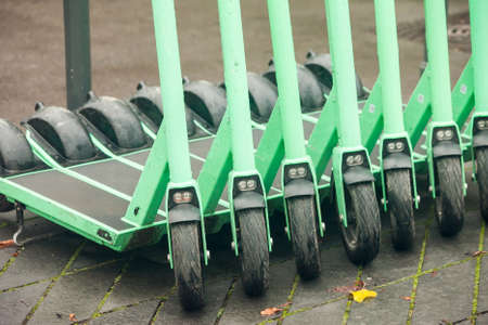 Electric scooters in row on the parking lot. City bike rental system, public kick scooters on the...