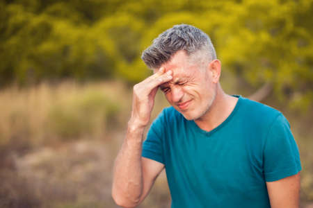 Headache. Man with head pain outdoor. Healthcare and medicine conceptの写真素材
