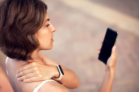 Neck pain using smartphone outdoor. Healthcare, lifestyle and technology conceptの写真素材