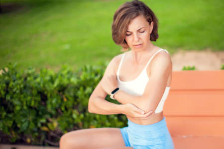 Elbow pain. Woman feeling arm ache outdoor. Healthcare and lifestyle conceptの写真素材