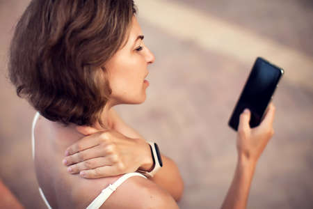 Neck pain using smartphone outdoor. Healthcare, lifestyle and technology conceptの写真素材