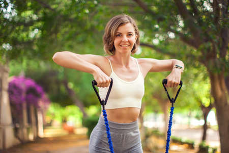 Exercise with fitness rubber bands outdoor. Woman training outdoor. Fitness and healthcare conceptの写真素材