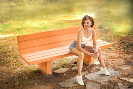 Sports woman drinking water in the park. Fitness and healthcare conceptの写真素材