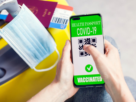 Health passport of vaccination in smartphone with qr-code, passport, tickets and luggage. Traveling during covid-19 pandemic.の写真素材
