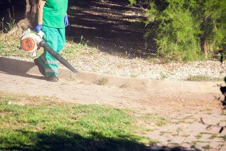 Leaf blower equipment using by worker in uniform to clean streetの写真素材