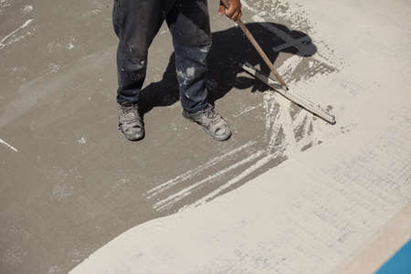 Worker laying concrete on the floor with a trowel.の写真素材