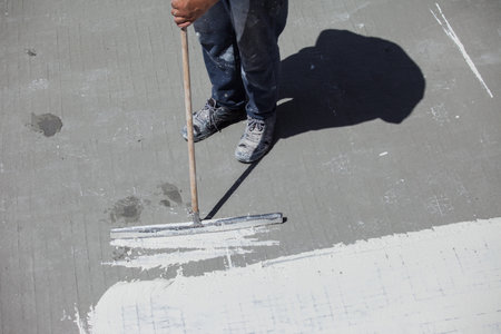 Worker with a mop cleans the floor with white paint.の写真素材