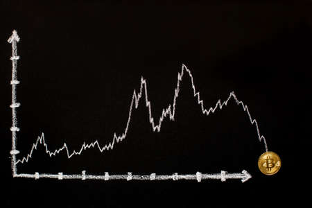 Cryptocurrency gold coin on a blackboard with a graph.の写真素材