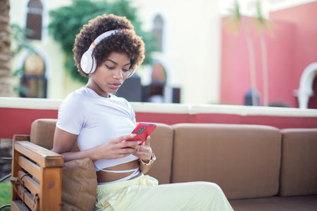 Portrait young lady out on the city street listening to music on her mobile phone. Lifestyle conceptの写真素材