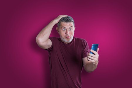 Confused serious man using mobile phone. Emotion conceptの写真素材