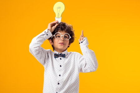 Child boy holding paper bulb. Success, motivation, winner, genius, idea conceptの写真素材