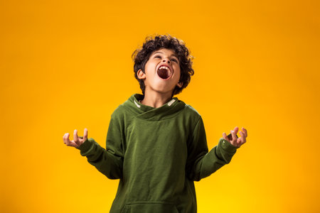 Portrait of child boy on yellow background.の写真素材