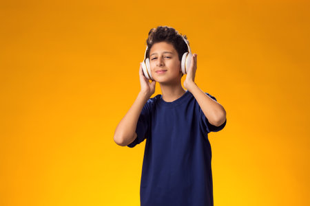Portrait of smiling kid boy with headphone listening to a music. Leisure and entertainment concept