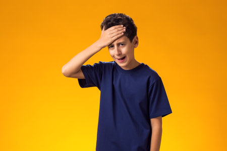 Portrait of stressed sad boy hands on temples, head spinning around, overwhelmed at school in life isolated grey background. Negative human facial expression emotion feeling, perceptionの写真素材