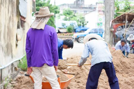 construction labour sweep sand to wheelbarrowのeditorial素材