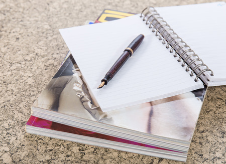 fountain pen on note book and magazineの写真素材
