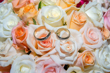 Wedding rings in a bouquet of roses.の写真素材