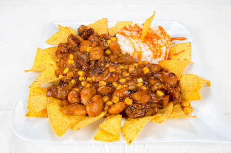 Dish of chips, beans, corn and white rice.