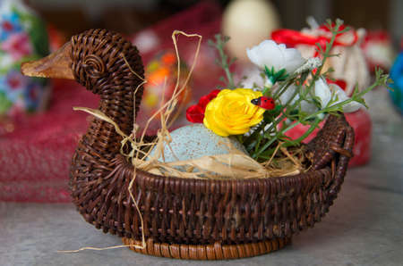 Decorated wicker basket with eggs and flowers.