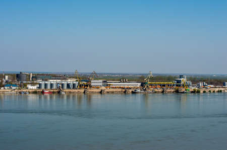 Cargo port with warehouses and industrial area on the banks of the river