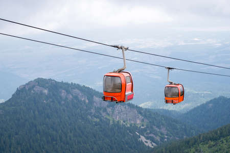 Red cable cabin. Gondola lift in mountain.