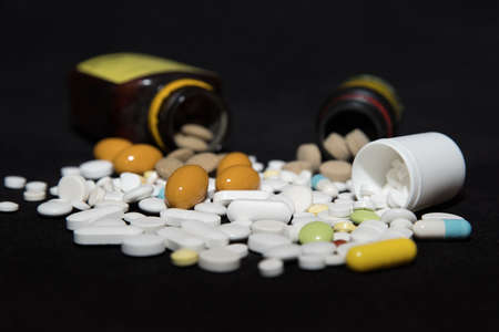 Pills spilling out of pill bottlesの写真素材