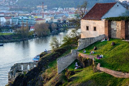 PRAGUE, CZECH REPUBLIC - APRIL 3, 2017: Young people are relaxing and watching the sunset on a hill in Vysehradのeditorial素材