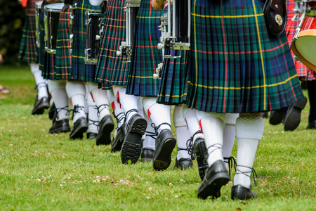 Photo of men below waist in green kilts and white socks are marching in New Zealandの写真素材