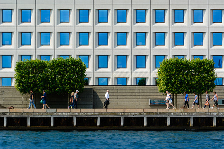 COPENHAGEN, DENMARK - JUNE 25 2016: People are walking in front of an office building located on the water front in Copenhagen.のeditorial素材
