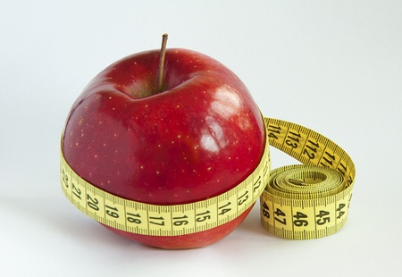 Yellow tape Measure with red Appleの写真素材