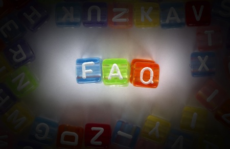 Text FAQ on colorful cubes over white. Letters scattered randomly over whiteの写真素材