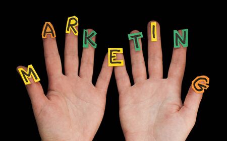 Word Marketing made from letters cut out. Two handsの写真素材