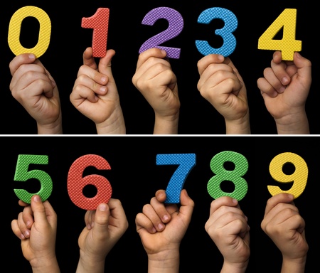 Children hands holding numbers. Black isolated multicolor numbers.の写真素材