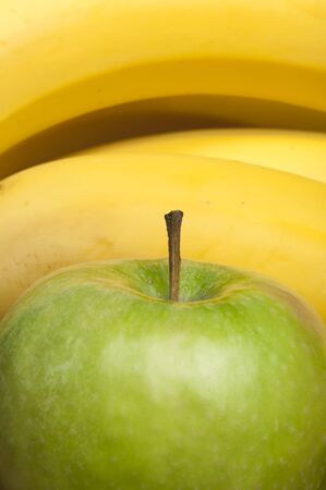 Green apple and bananas close up backgroundの写真素材