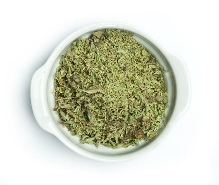 Dried oregano in a bowl on white backgroundの写真素材
