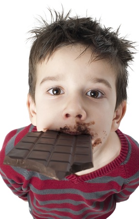 Smiling kid eating chocolate. Smeared stained with chocolate lips. White isolatedの写真素材