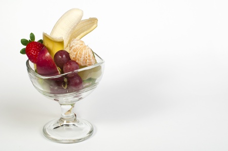 Fruit salad in a glass bowl on white backgroundの写真素材
