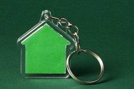 Keychain with figure of green house on green backgroundの写真素材