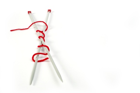 Knitting skewers and red yarn white isolatedの写真素材