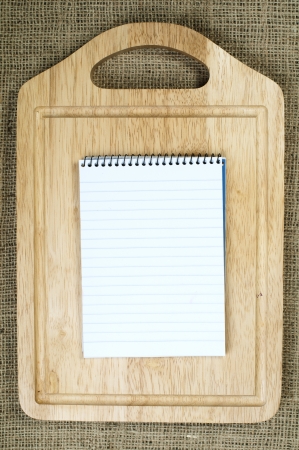 Notebook to write recipes and vegetables around itの写真素材
